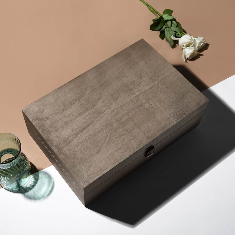 Closed walnut memory box styled on a tabletop with small decor.