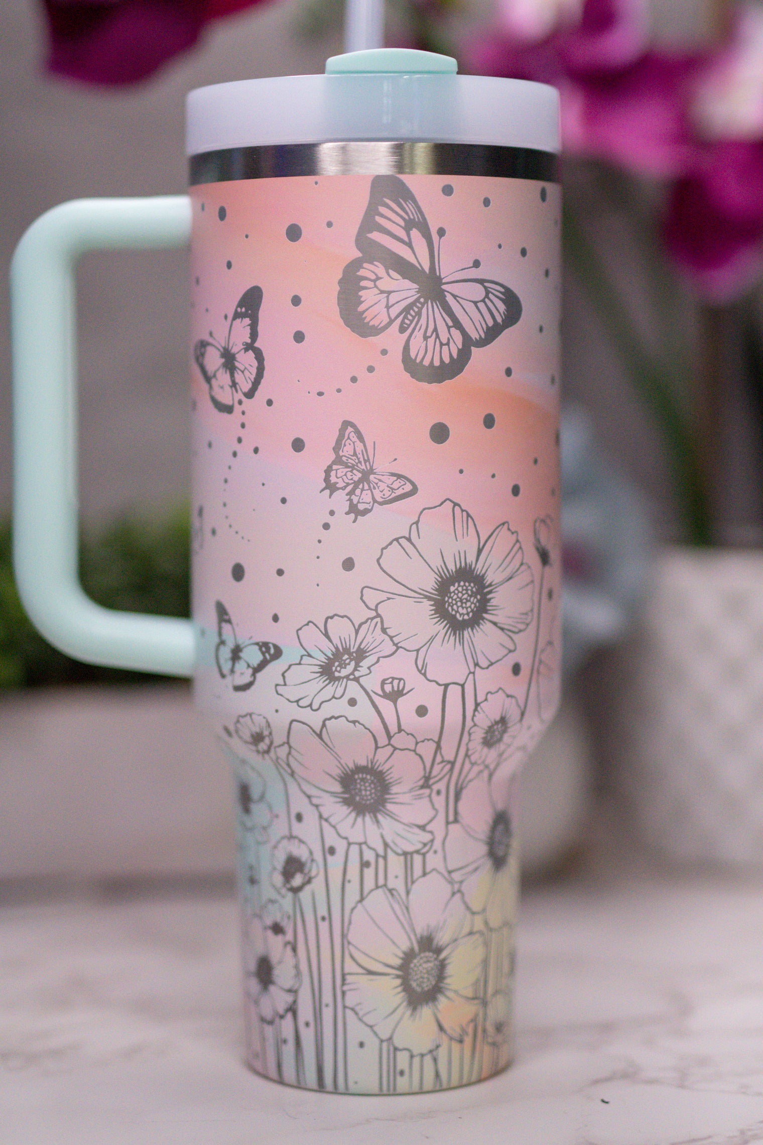 a cup with a butterfly design on it sitting on a table