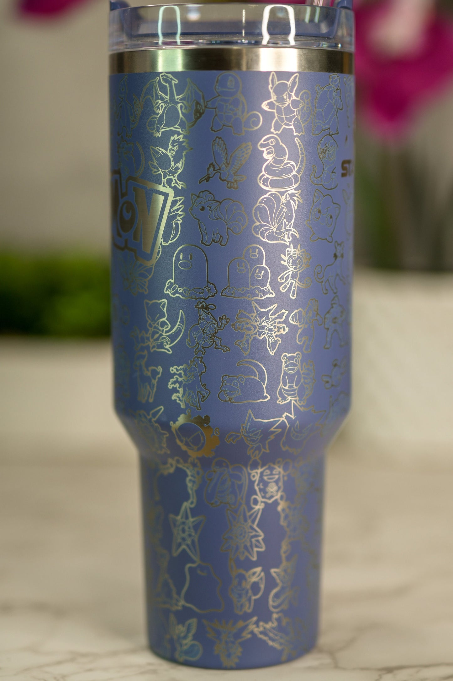 a blue tumbler cup with gold designs on it