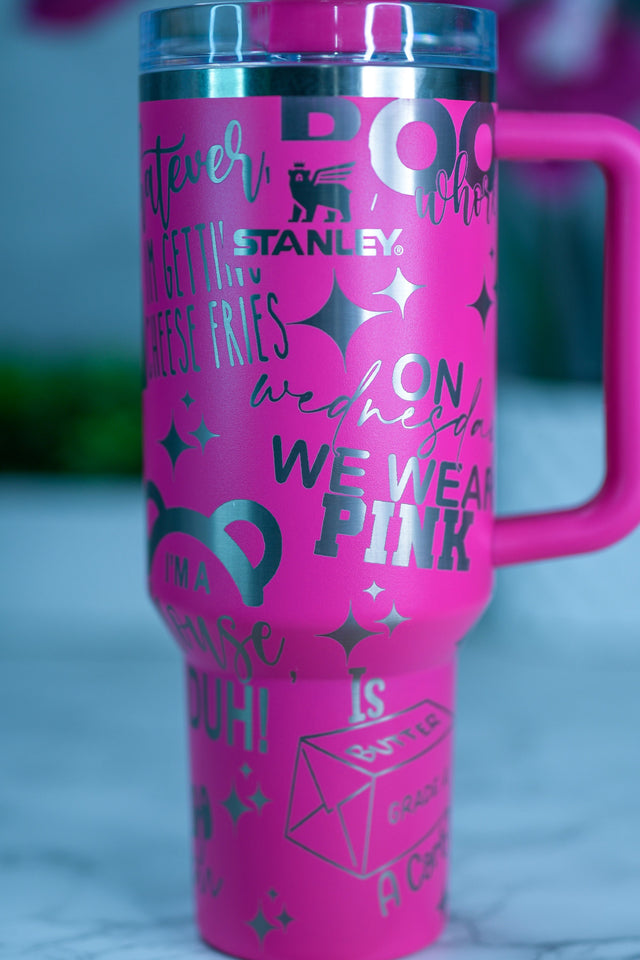 a pink travel mug with black writing on it