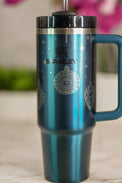 a blue travel mug sitting on top of a table