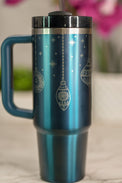 a blue travel mug with christmas ornaments on it