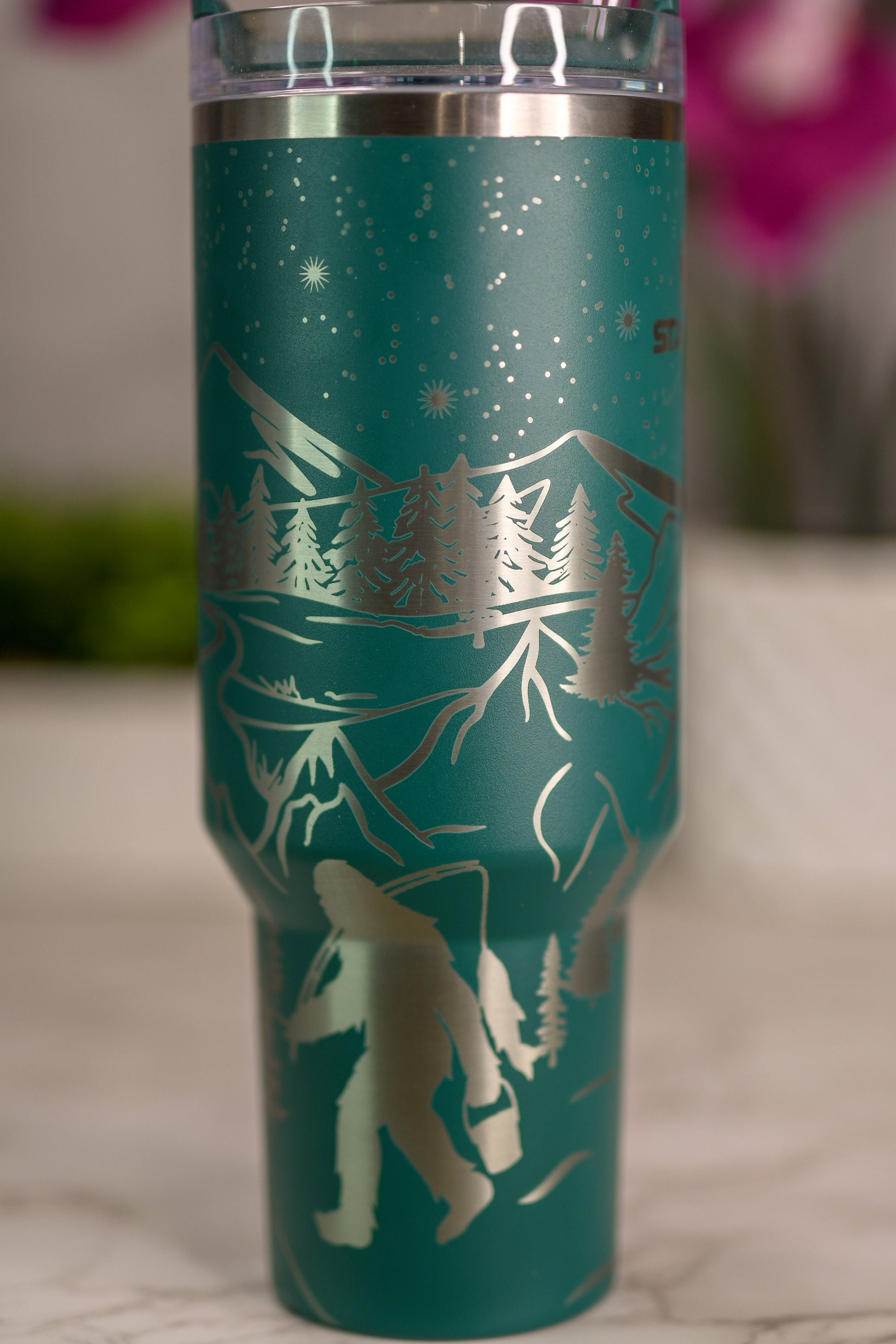 a green travel mug with a picture of a bear on it